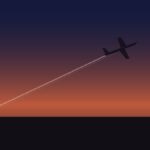 An airplane silhouette with a contrail against a sunset sky